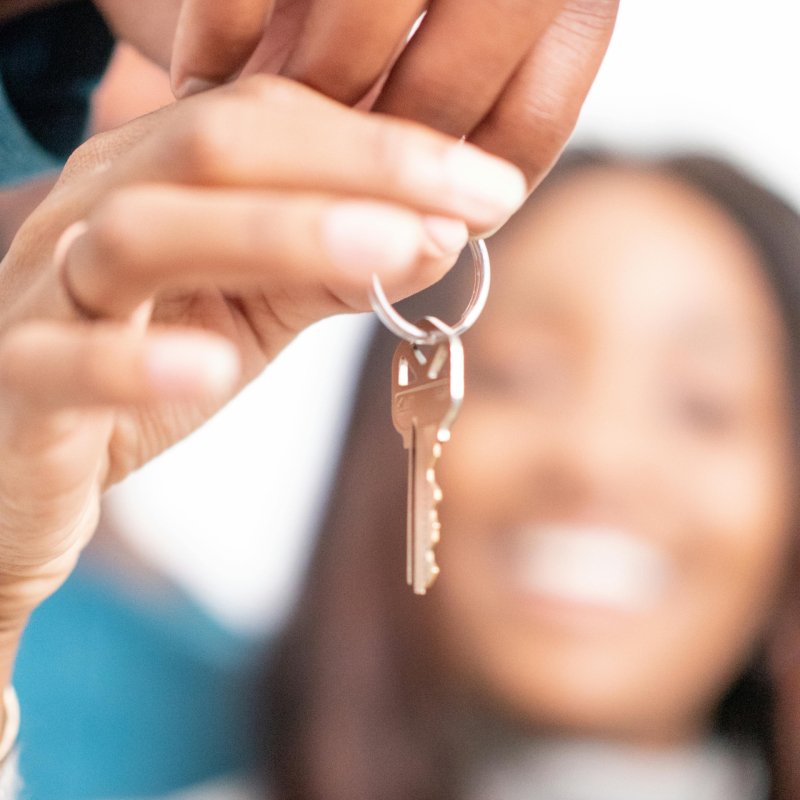 Joyful moment of new homeowners receiving keys to their new house, symbolizing hope and new beginnings.